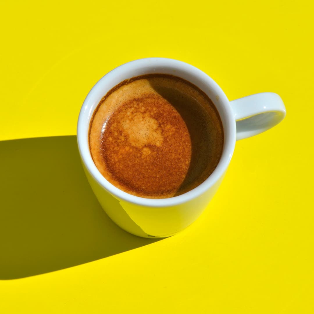 Tasse d'espresso sur une table jaune